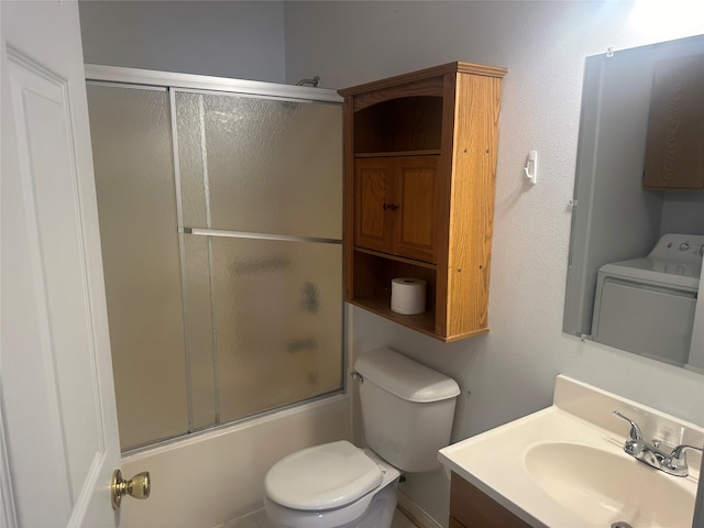 full bathroom featuring toilet, vanity, bath / shower combo with glass door, and washer / dryer