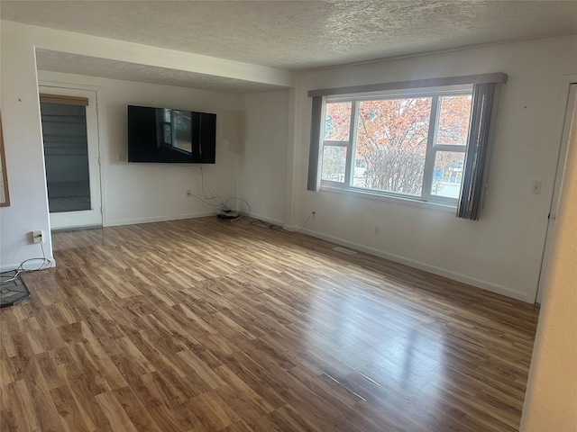 interior space featuring wood-type flooring and a textured ceiling