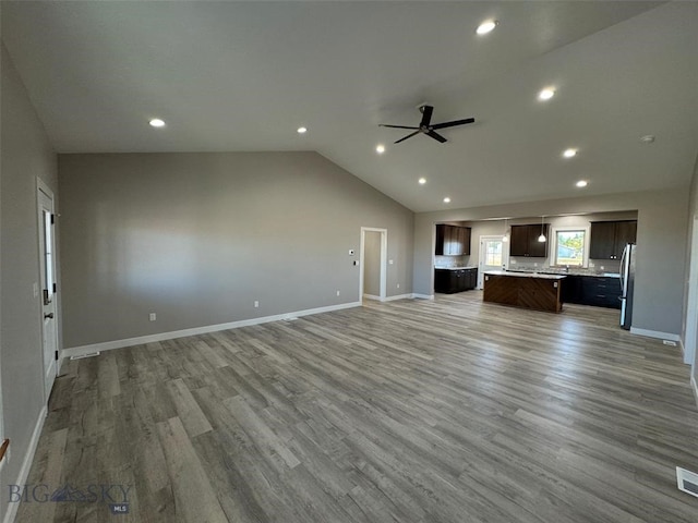 unfurnished living room with vaulted ceiling, ceiling fan, and hardwood / wood-style floors