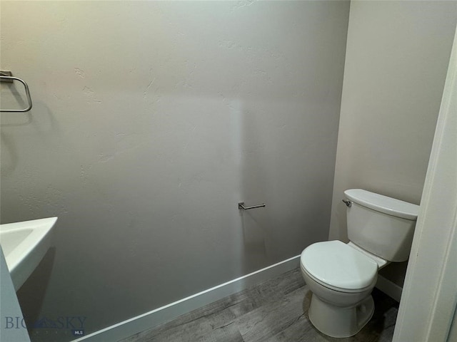 bathroom with hardwood / wood-style floors and toilet