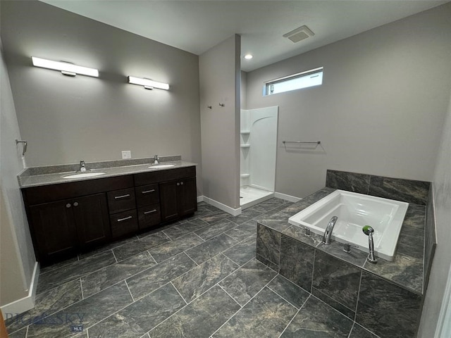 bathroom featuring vanity and a relaxing tiled tub