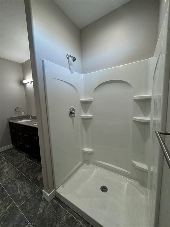 bathroom featuring walk in shower and vanity