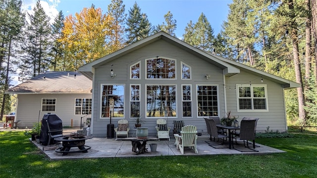 rear view of house with an outdoor fire pit, a patio, and a yard