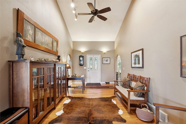 entryway featuring high vaulted ceiling, light wood-type flooring, baseboards, and a ceiling fan