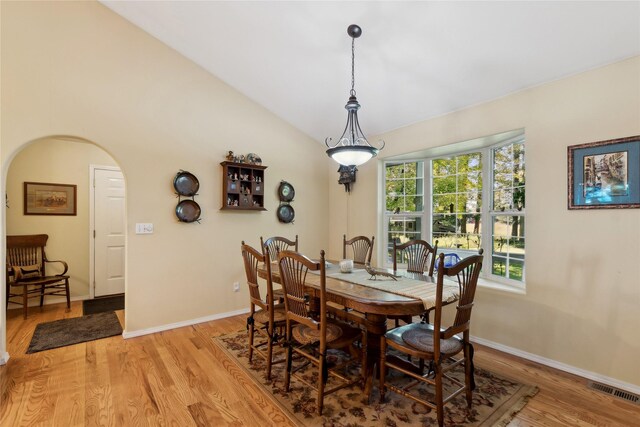 dining space featuring vaulted ceiling and light hardwood / wood-style flooring