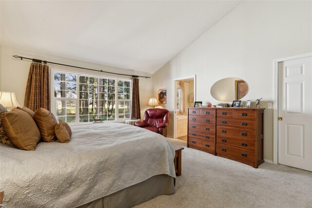 carpeted bedroom featuring high vaulted ceiling and connected bathroom