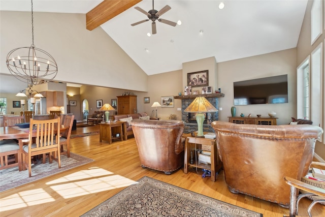 living room with beam ceiling, light wood-type flooring, ceiling fan with notable chandelier, and high vaulted ceiling