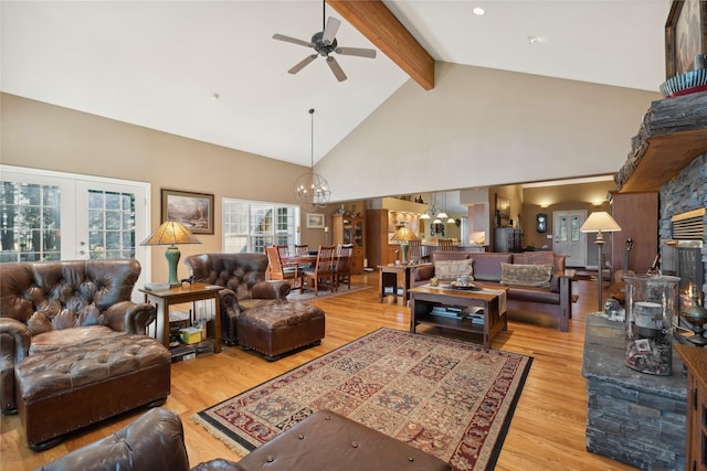 living room with ceiling fan with notable chandelier, high vaulted ceiling, beam ceiling, and wood finished floors