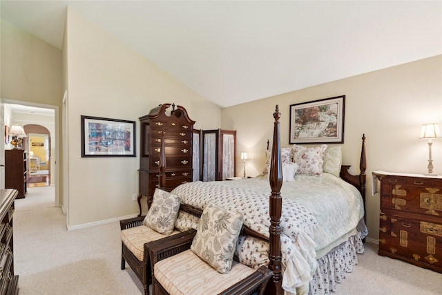 bedroom featuring carpet floors, arched walkways, lofted ceiling, and baseboards