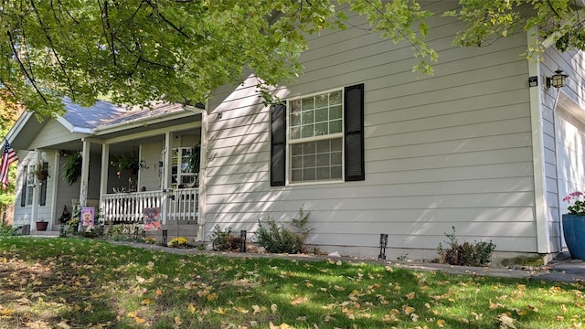 view of property exterior featuring a yard and a porch