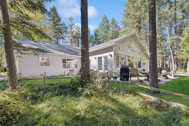 rear view of house featuring a patio area and a yard