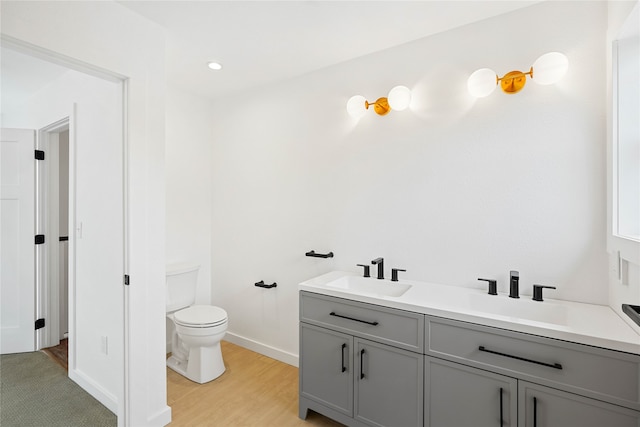 bathroom featuring vanity, hardwood / wood-style floors, and toilet