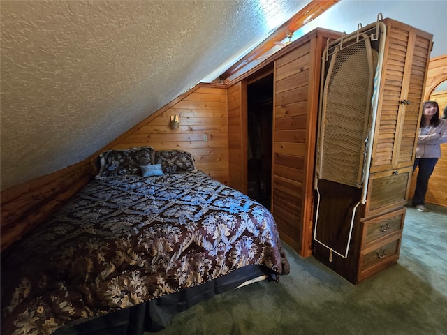 bedroom with a textured ceiling, carpet flooring, and wooden walls