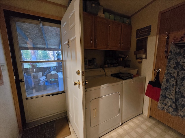 clothes washing area featuring washer and clothes dryer and cabinets