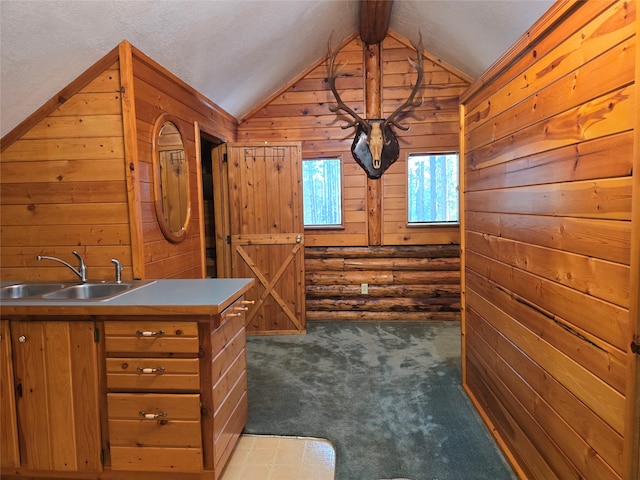 interior space featuring vaulted ceiling with beams, sink, and dark carpet