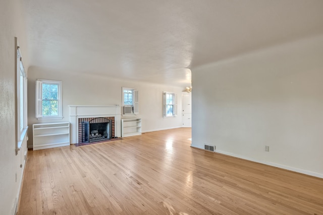 unfurnished living room with a fireplace and light wood-type flooring