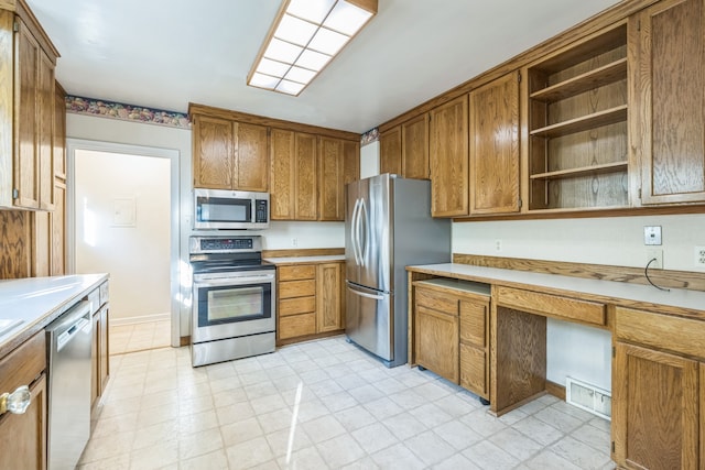 kitchen with built in desk and appliances with stainless steel finishes