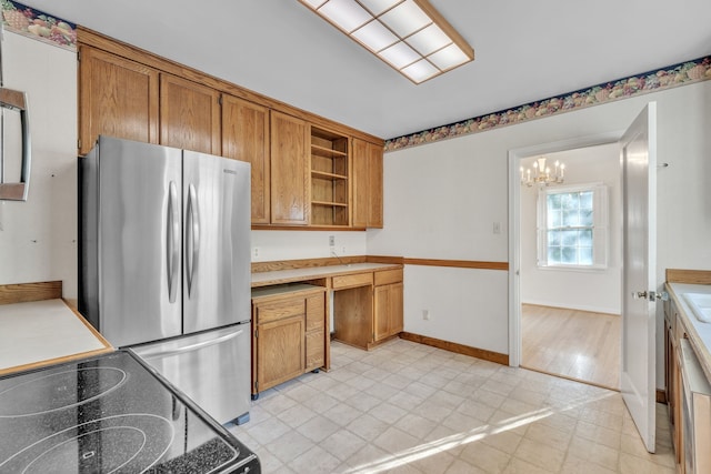 kitchen with light wood-type flooring, stainless steel refrigerator, stove, and a notable chandelier