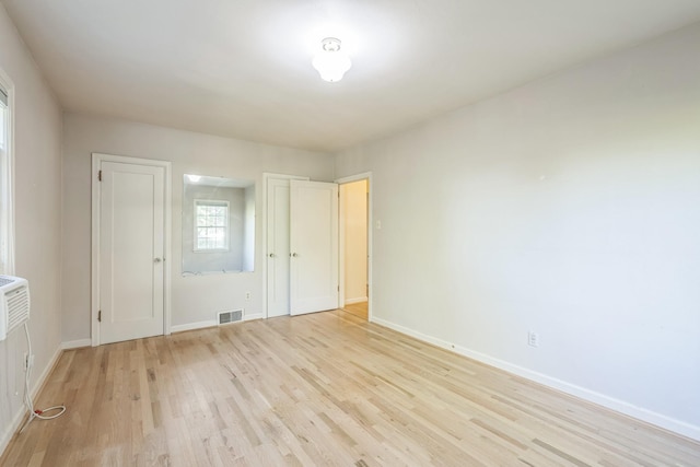 unfurnished bedroom featuring baseboards, visible vents, and light wood finished floors