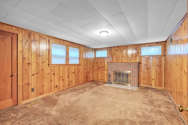 basement featuring carpet flooring, a fireplace, and wooden walls