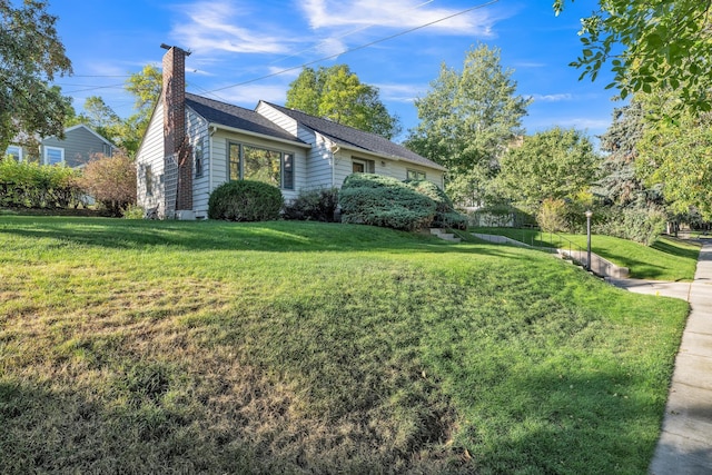 view of front of house with a chimney and a front lawn