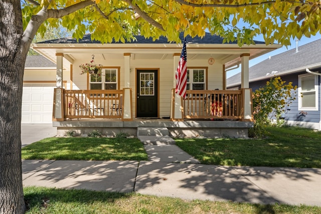 view of front facade with a garage, a front lawn, and a porch