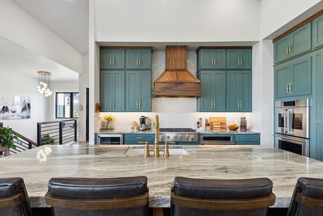 kitchen featuring a breakfast bar area, stainless steel double oven, hanging light fixtures, custom exhaust hood, and light stone countertops