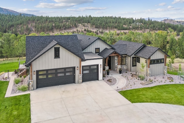 modern inspired farmhouse with a garage, a mountain view, and a front yard