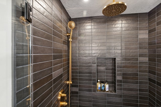 bathroom featuring a textured ceiling and tiled shower