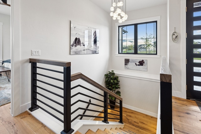 staircase featuring a notable chandelier and hardwood / wood-style flooring