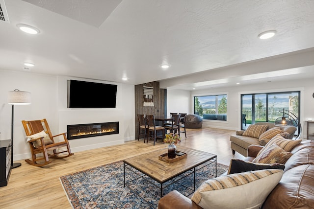 living room featuring a textured ceiling and light hardwood / wood-style floors