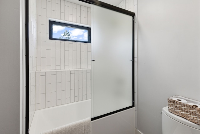 bathroom with shower / bath combination with glass door and toilet