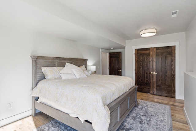 bedroom with hardwood / wood-style floors and a closet