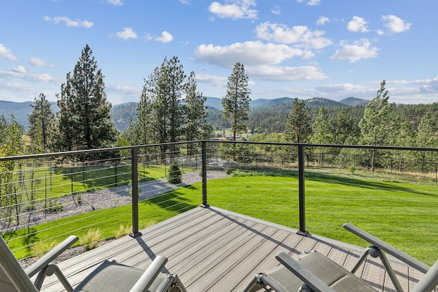 wooden deck with a mountain view and a lawn