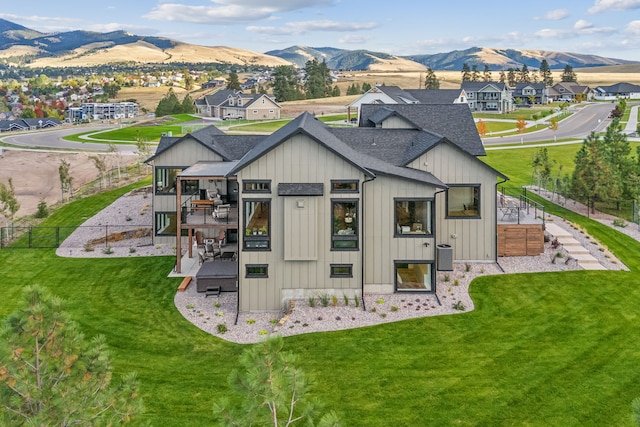 rear view of house featuring a lawn, a mountain view, central AC unit, and a patio area