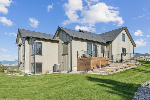 back of property with a lawn and central air condition unit