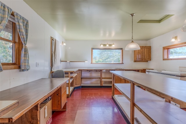 2237 Grave Creek Rd, Eureka, MT 59917 - kitchen with brown cabinetry, dark floors, pendant lighting, and light countertops