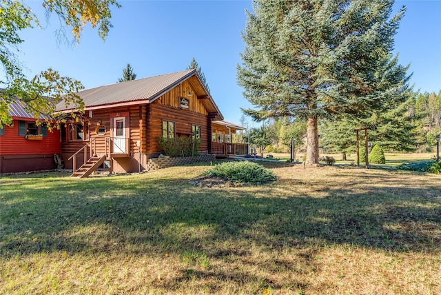 2237 Grave Creek Rd, Eureka, MT 59917 - rear view of property featuring log siding, a yard, and a metal roof