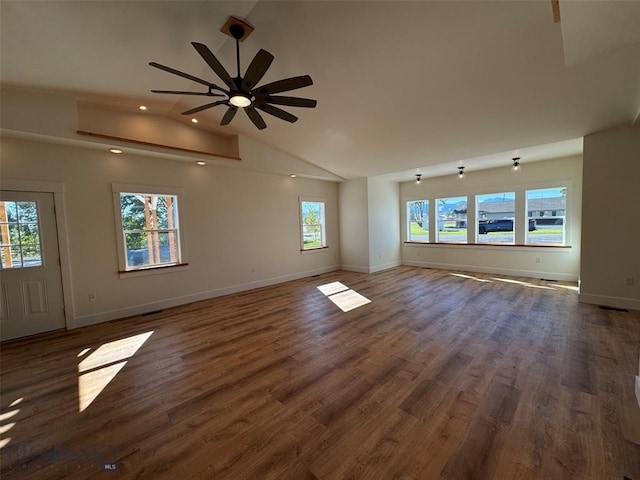 unfurnished living room with lofted ceiling, dark hardwood / wood-style floors, ceiling fan, and plenty of natural light