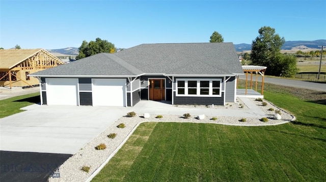 view of front of house with a mountain view, a front lawn, and a garage