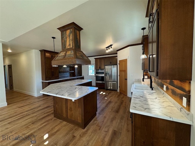 kitchen featuring sink, a kitchen island, stainless steel appliances, dark hardwood / wood-style floors, and light stone countertops