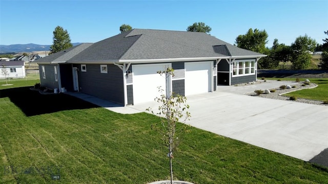 view of front of home with a mountain view, a garage, and a front lawn