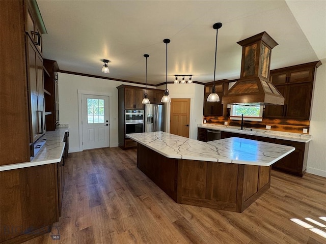 kitchen featuring stainless steel appliances, decorative light fixtures, dark hardwood / wood-style flooring, ornamental molding, and light stone countertops