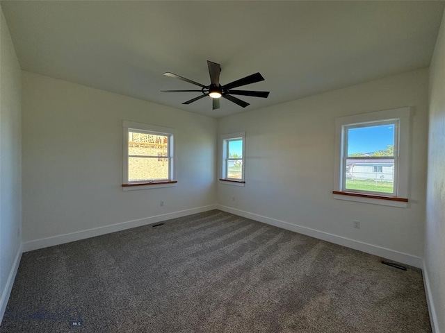 empty room featuring dark colored carpet and ceiling fan