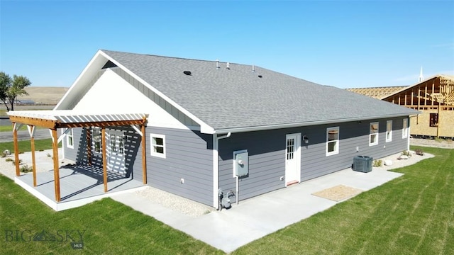 rear view of property featuring central AC unit, a yard, and a patio area