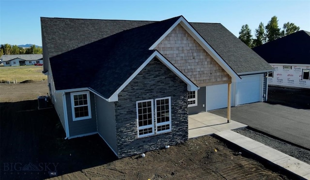 view of front of home featuring cooling unit and a garage