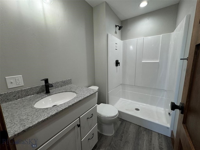 bathroom with vanity, a shower, toilet, and hardwood / wood-style flooring