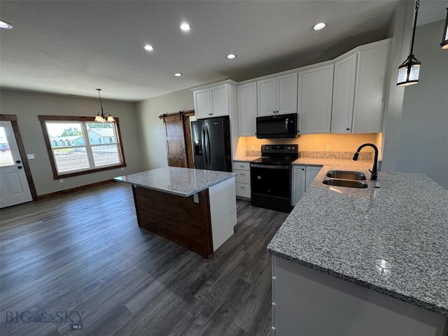 kitchen with pendant lighting, white cabinets, sink, dark wood-type flooring, and black appliances