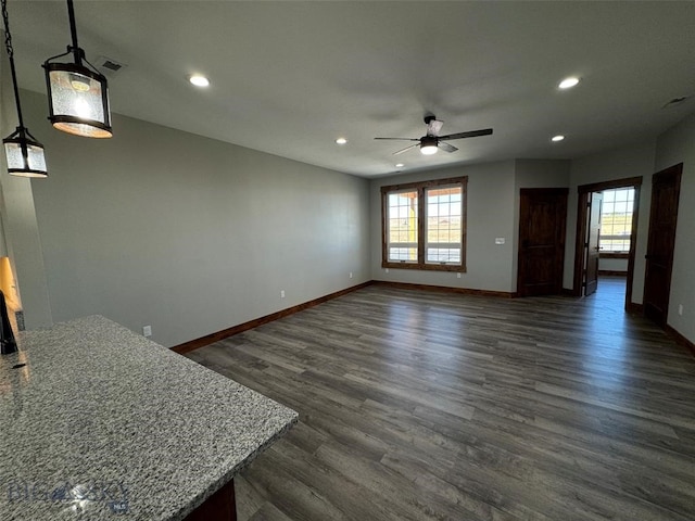 unfurnished living room featuring ceiling fan and dark wood-type flooring