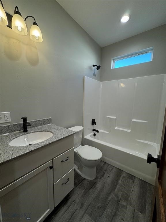 full bathroom featuring vanity, lofted ceiling, shower / bath combination, hardwood / wood-style flooring, and toilet